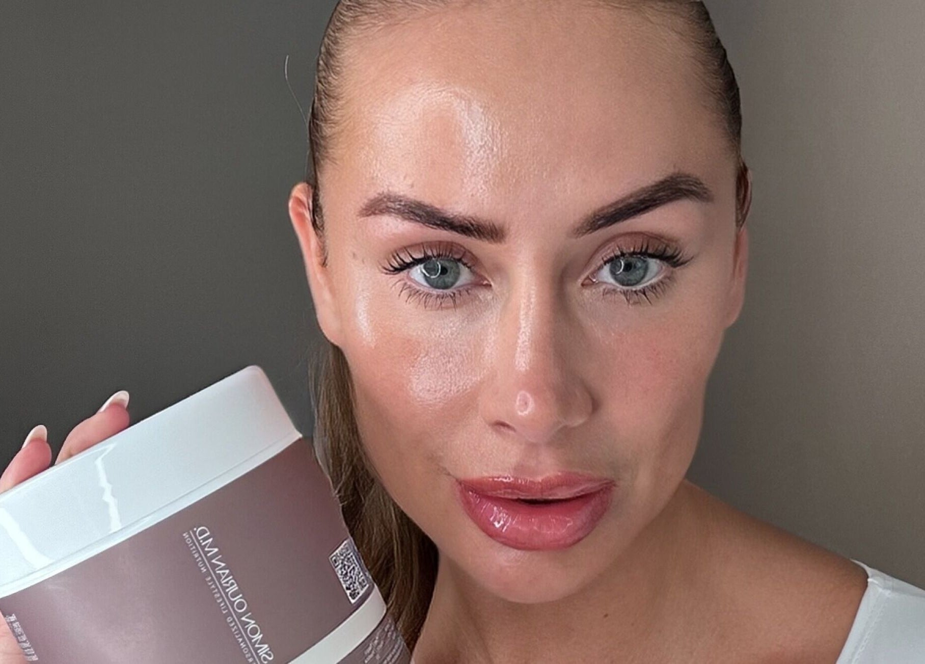 A radiant individual showcasing skincare product at SKN Lab Yorkshire, Wakefield, England, GB.