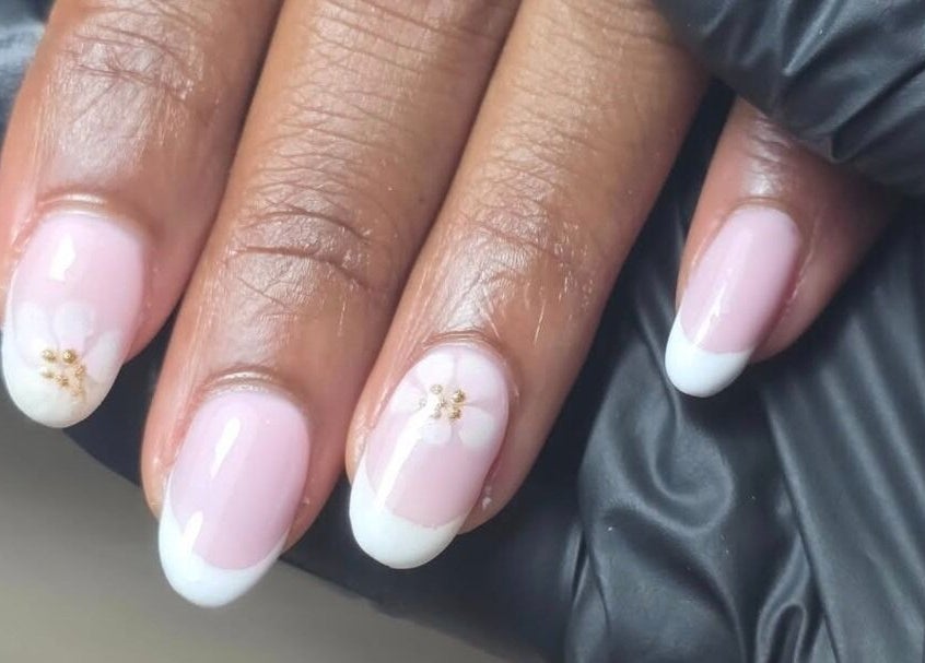 Elegant floral nail design at MANI.FEST Nails, Barry, Wales, GB, showcasing pink and white detailing.