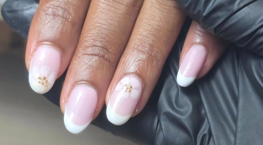 Elegant floral nail design at MANI.FEST Nails, Barry, Wales, GB, showcasing pink and white detailing.