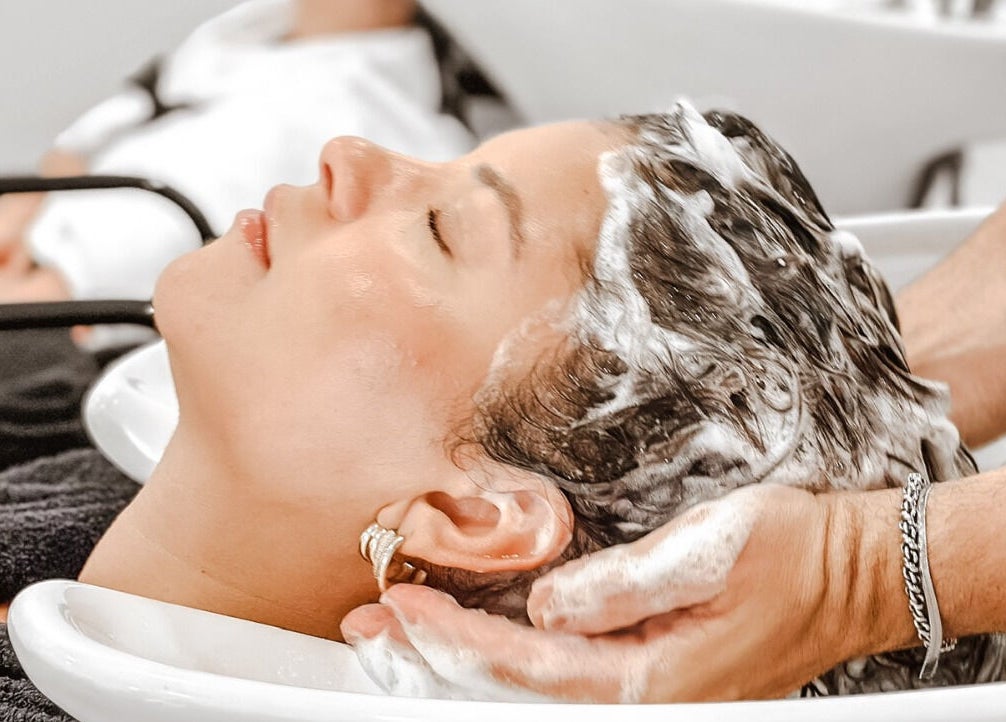 Cabeleireiro lavando cabelo em Studio Unique, Porto, Porto, PT. Relaxamento e cuidado premium.