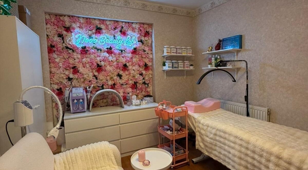 Noor Beauty Lab treatment room with floral wall in Enfield, England, GB.