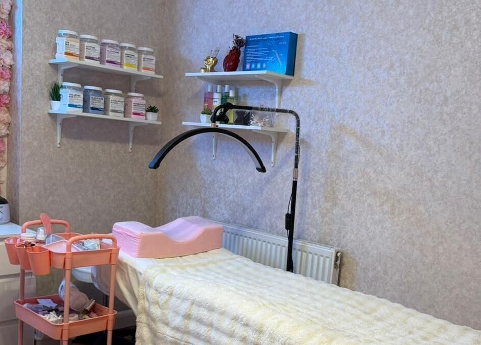 A cozy treatment room at Noor Beauty Lab, Enfield, England, GB with floral decor and skincare products.