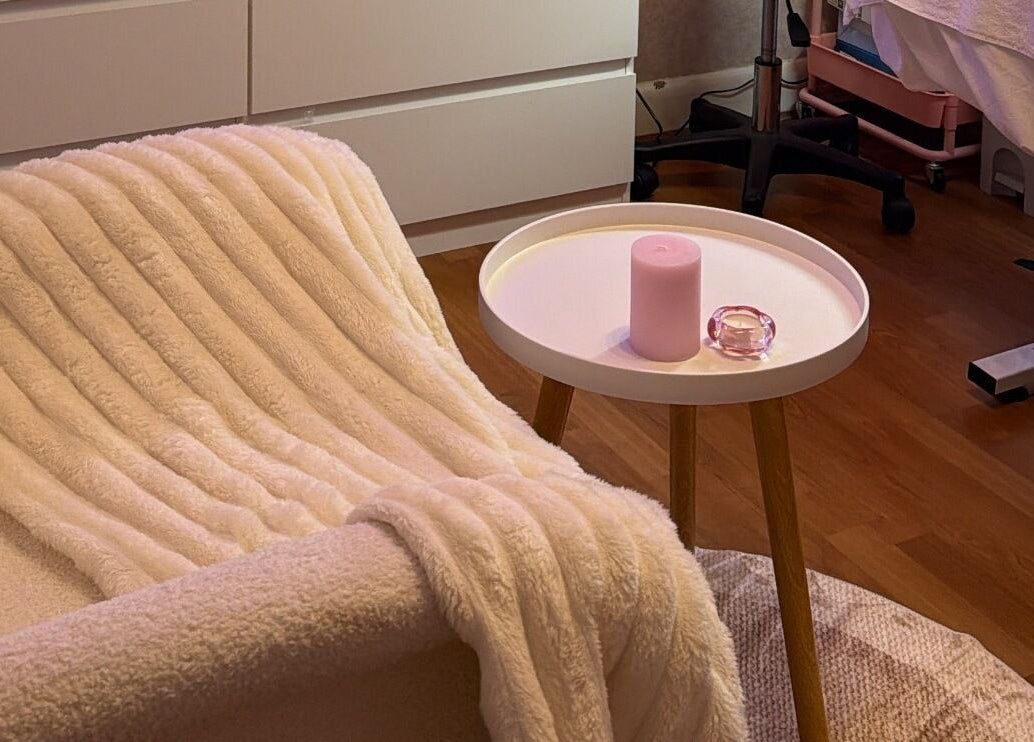 Relaxing chair with a plush blanket at Noor Beauty Lab, Enfield, England, GB. Experience ultimate comfort.
