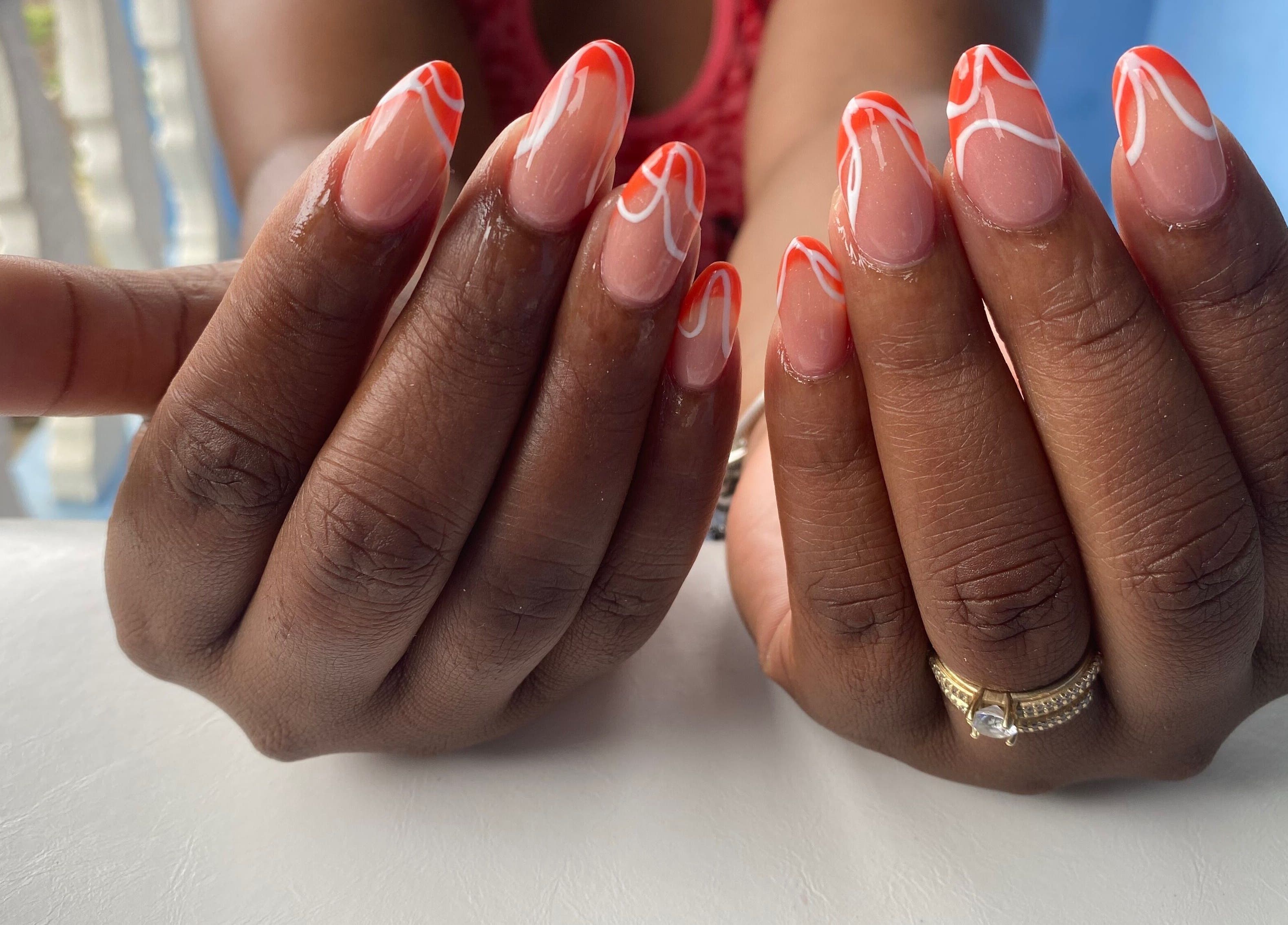 Stylish manicure with orange and white design at NailzbyTan, Biabou, Charlotte, VC.