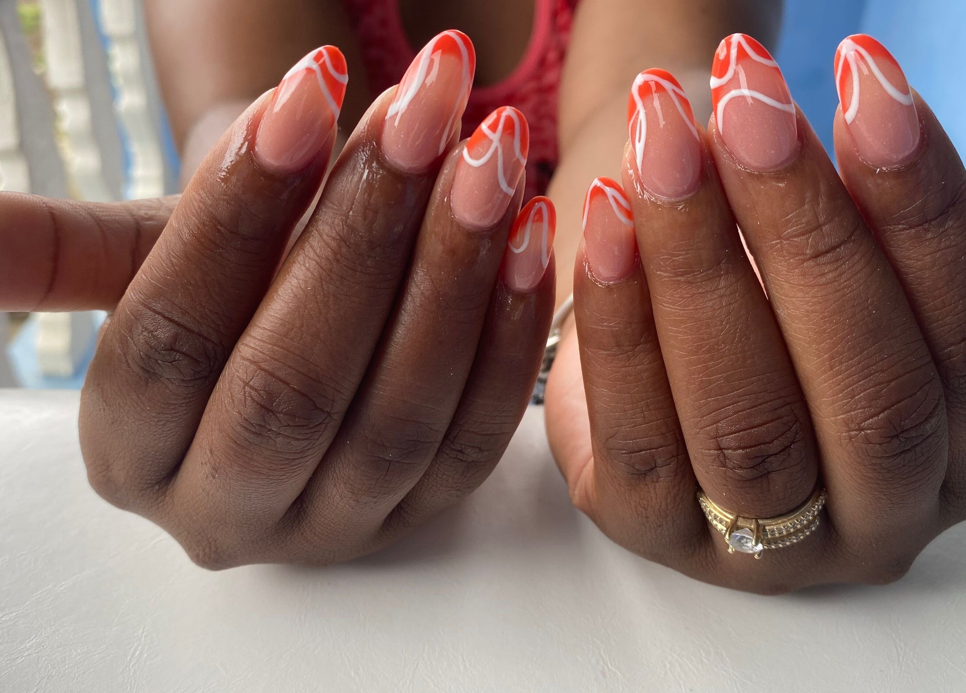 Stylish manicure with orange and white design at NailzbyTan, Biabou, Charlotte, VC.