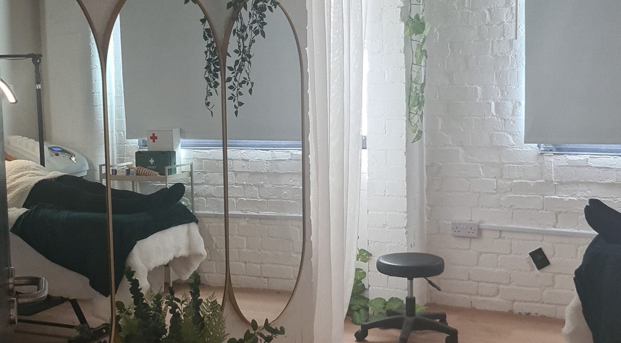 Tranquil treatment room at Finesse Wellness Clinic, Leicester, England, GB, with cozy bed and elegant decor.