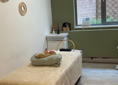Salle de soin apaisante à Halo of Head Spa, Uccle, Bruxelles, BE, avec table de massage cosy et décor relaxant.