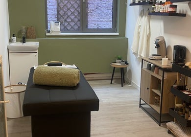 Salle de soins élégante chez Halo of Head Spa, Uccle, Bruxelles, BE, avec table de massage et décor apaisant.