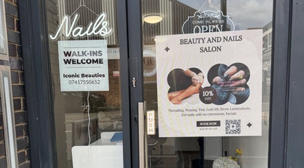 Entrance to Iconic Beauties salon in Hayes, England with signs for walk-ins and beauty services.