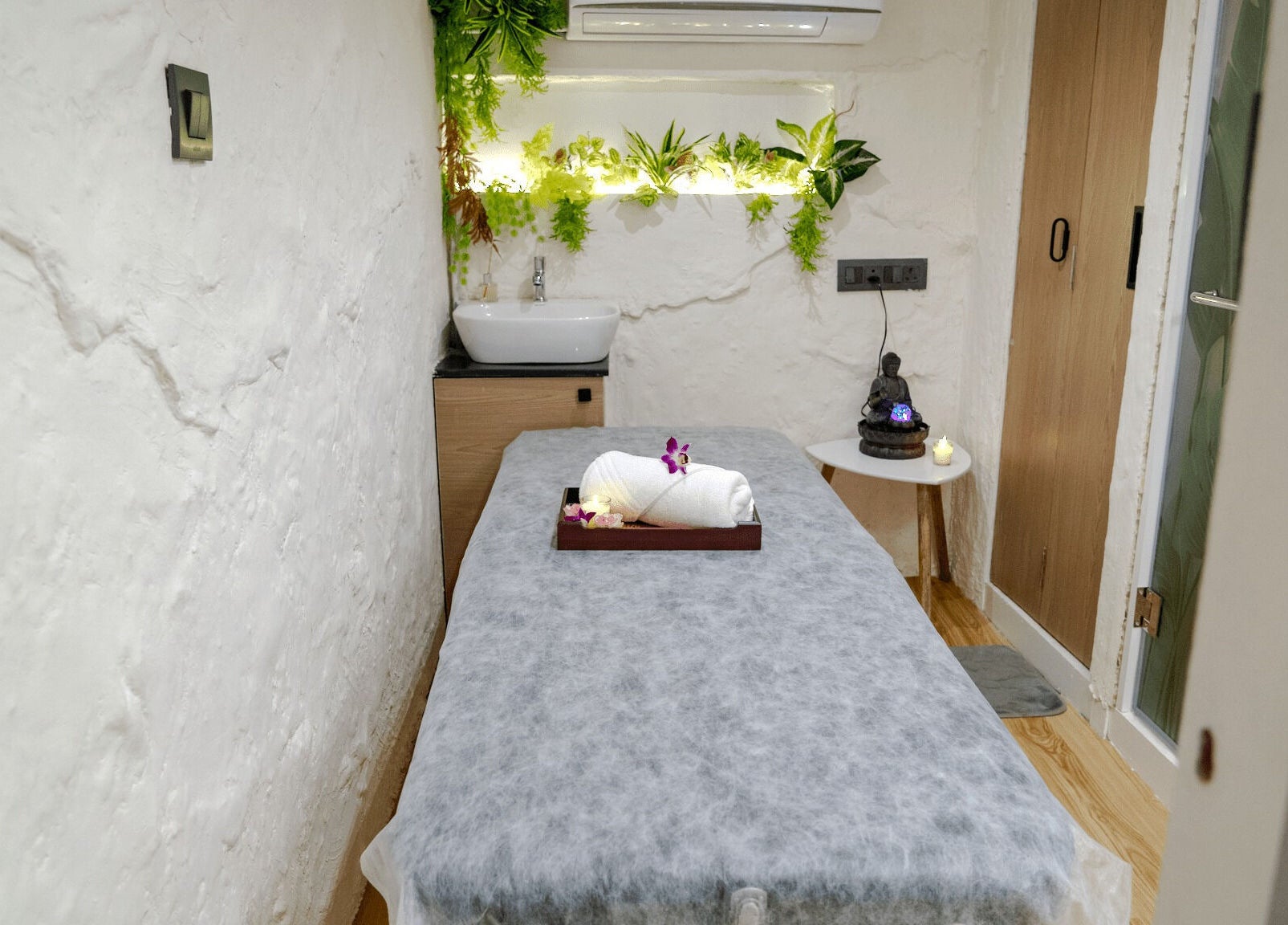 Tranquil spa room at Mist Salon, Spa & Nail Salon in Pune, Maharashtra, IN, featuring a massage bed with flowers.