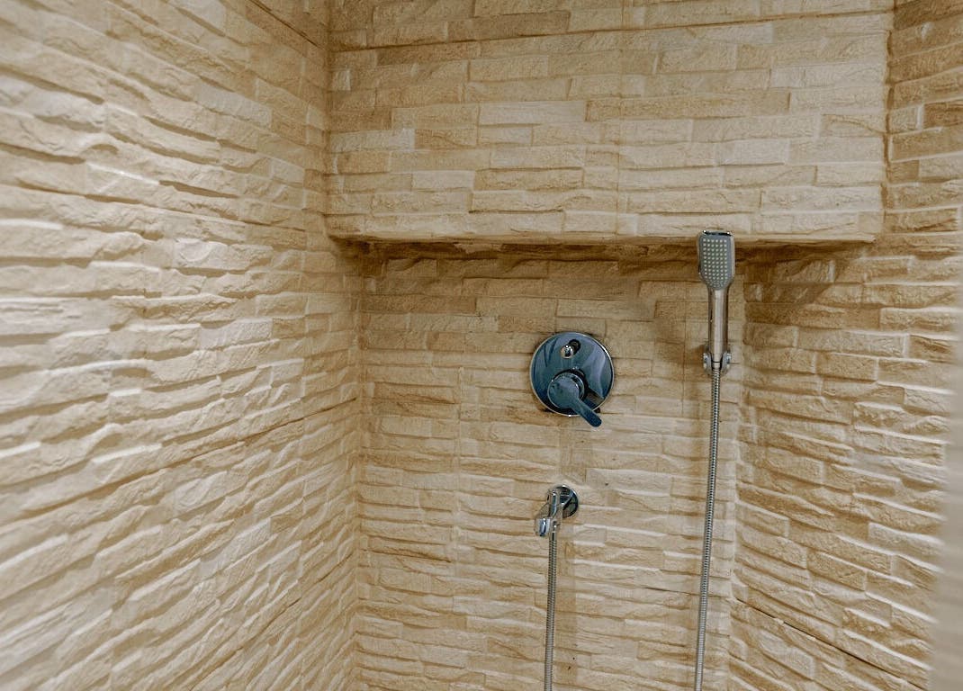 Elegant stone-finished shower at Mist Salon, Spa & Nail Salon in Pune, Maharashtra, IN.
