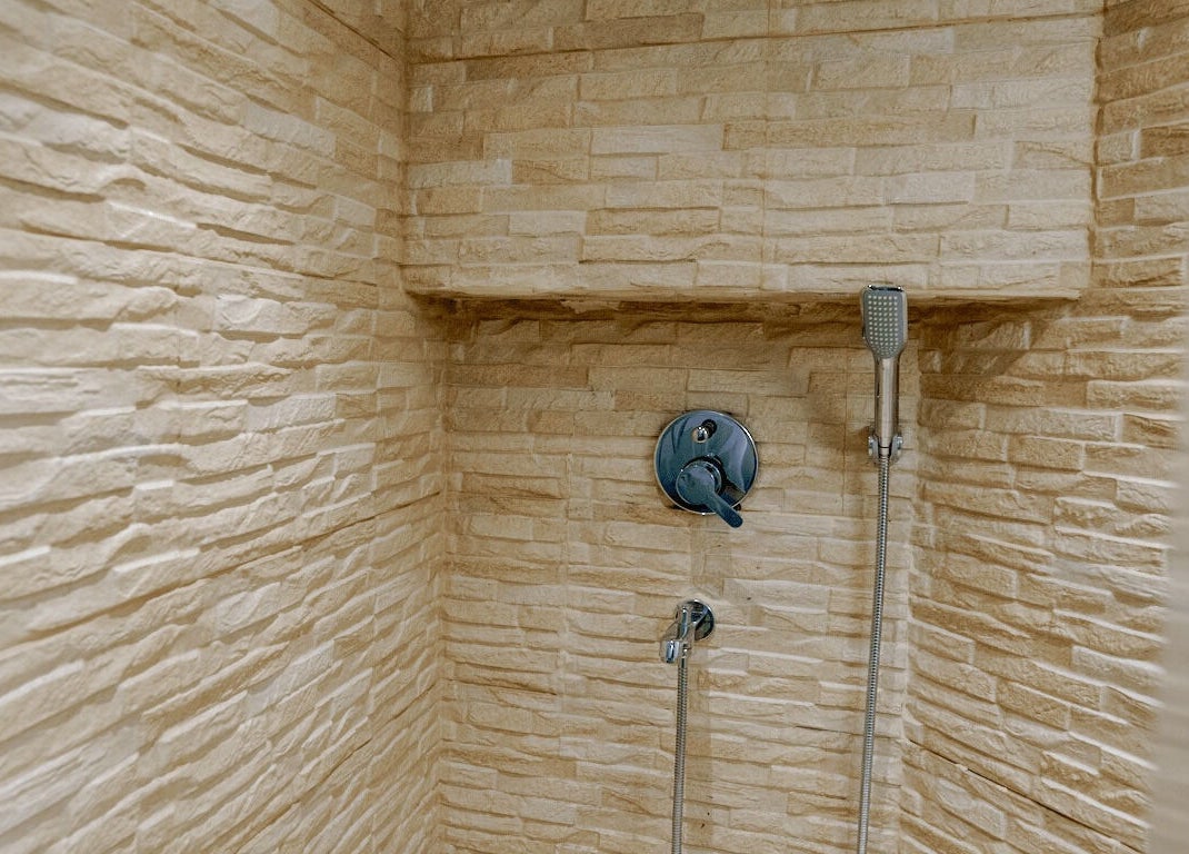 Elegant stone-finished shower at Mist Salon, Spa & Nail Salon in Pune, Maharashtra, IN.