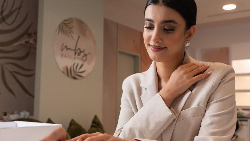 Woman receiving a manicure at MBS Nails Spa, Muscat, OM, showcasing elegant nail care service.