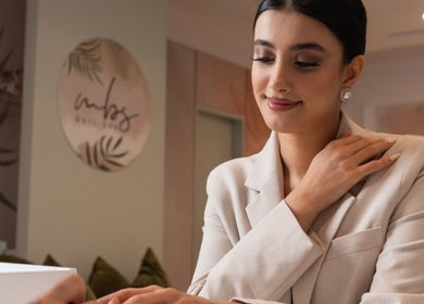Woman receiving a manicure at MBS Nails Spa, Muscat, OM, showcasing elegant nail care service.