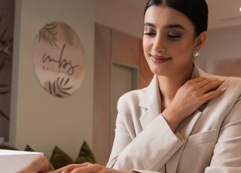 Woman receiving a manicure at MBS Nails Spa, Muscat, OM, showcasing elegant nail care service.