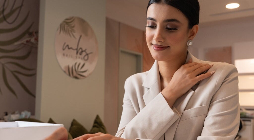 Woman receiving a manicure at MBS Nails Spa, Muscat, OM, showcasing elegant nail care service.