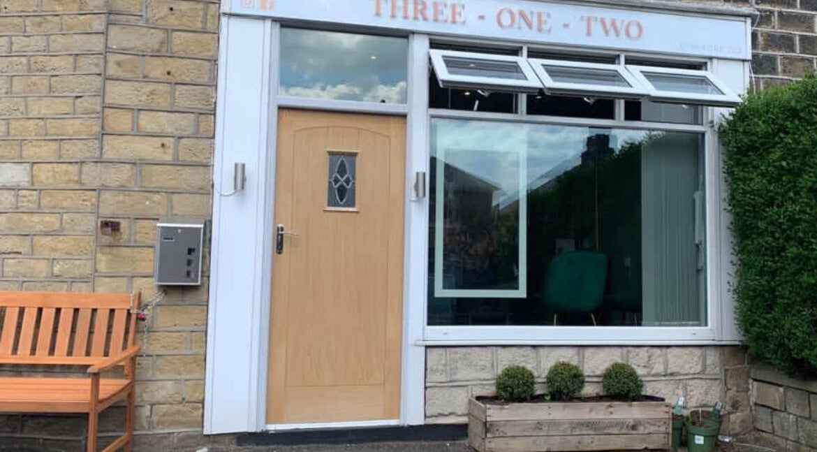 Exterior of Three one two hair salon in Golcar, England, GB with stone walls and a welcoming wooden door.