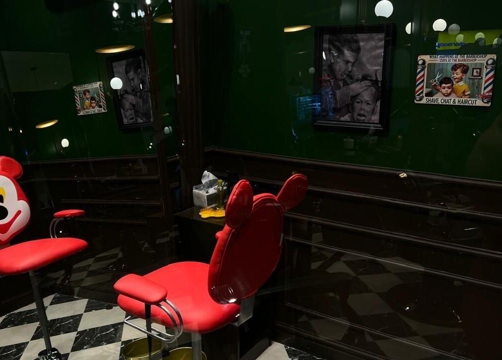 Bright red playful chair at Kingsman Barbershop in Riyadh, Riyadh Province, SA, offering a unique salon experience.