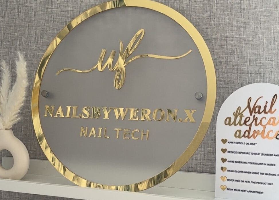 Elegant sign with gold accents at Nails By Weron, Halifax, England, GB, showcasing nail tech services.