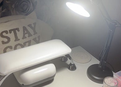 Nail station at Nails By Weron, Halifax, England, GB, featuring a cozy pillow and bright lamp.