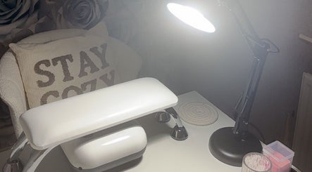 Nail station at Nails By Weron, Halifax, England, GB, featuring a cozy pillow and bright lamp.