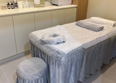 Yun Massage在澳大利亚新南威尔士州Eastwood的舒适按摩室，配有毛巾和护理产品。
