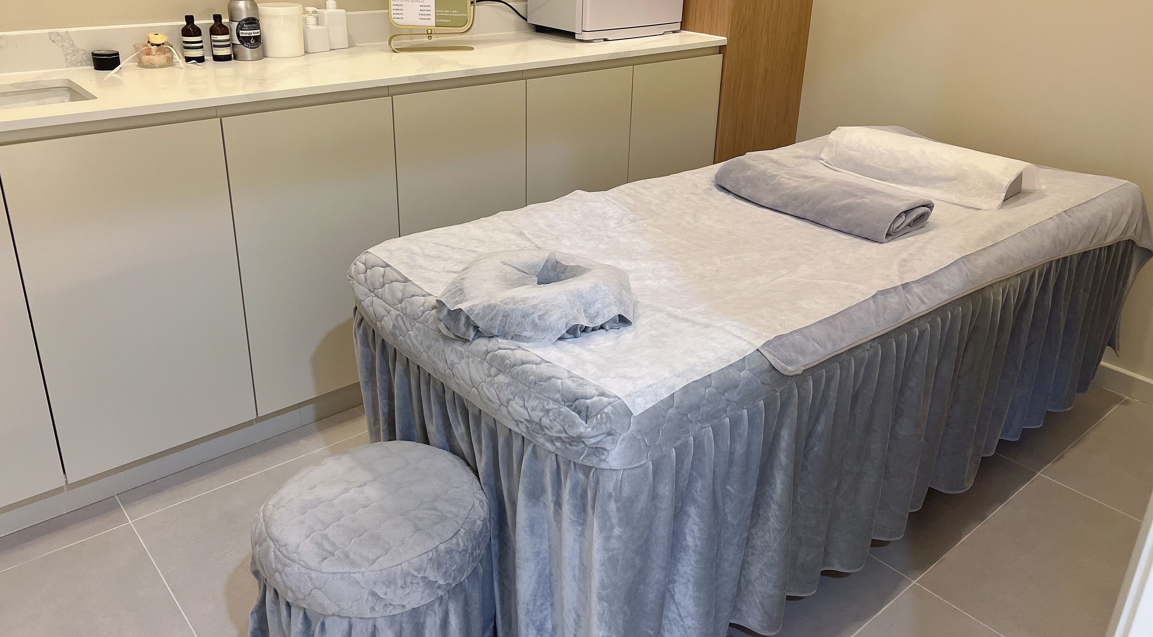 Yun Massage在澳大利亚新南威尔士州Eastwood的舒适按摩室，配有毛巾和护理产品。