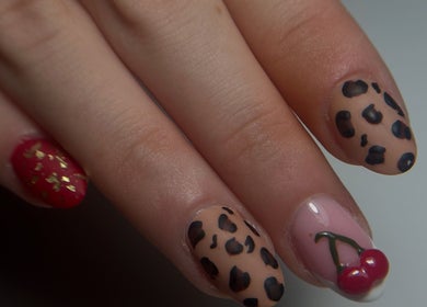 Designs d'ongles léopard et cerise à Le Coin Beauté De Gwen, Méziré, Bourgogne-franche-comté, FR.