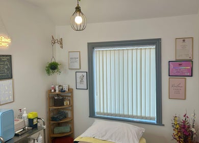 Calming treatment room at Flourishskinroom, Coventry, England, GB, with serene decor and glowing sign.