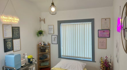 Calming treatment room at Flourishskinroom, Coventry, England, GB, with serene decor and glowing sign.