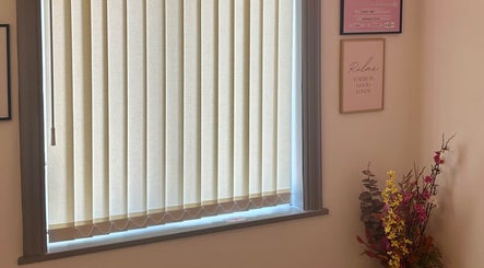 A calming window view with floral decor at Flourishskinroom in Coventry, England, GB.