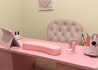 Elegant pink salon desk setup at Looklush, Wolverhampton, England, GB, featuring nail tools and plush chair.
