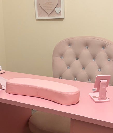 Elegant pink salon desk setup at Looklush, Wolverhampton, England, GB, featuring nail tools and plush chair.