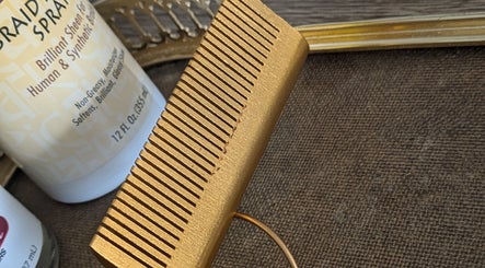 A golden comb and hair spray at Teya Hair, Mission, British Columbia, CA, showcasing premium hair care tools.