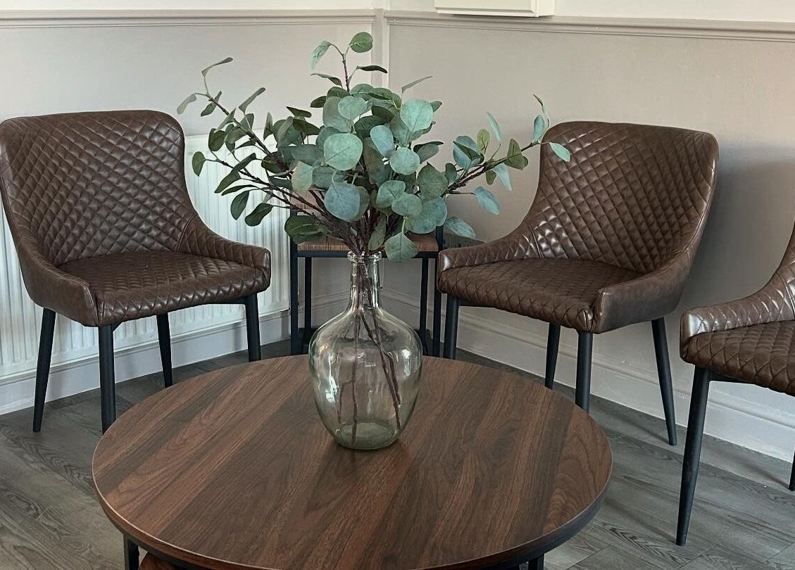 Elegant seating area with brown chairs and vase at CK Beauty Studios, Ilkeston, England, GB.