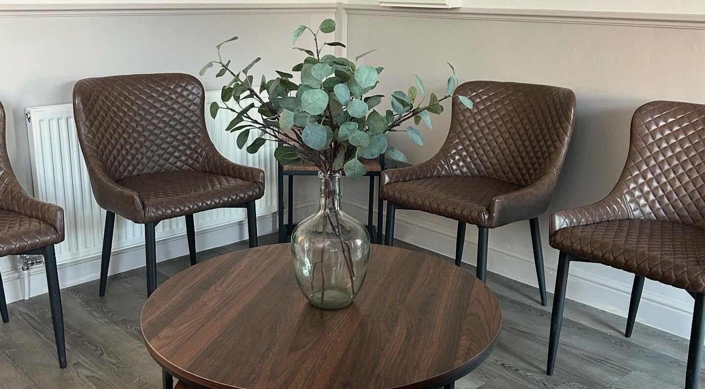 Elegant seating area with brown chairs and vase at CK Beauty Studios, Ilkeston, England, GB.