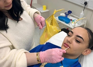 Aesthetician applying lip treatment at The Beauty Clinic By Paige, Uxbridge, England, GB.