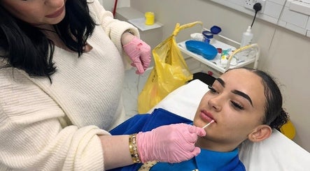 Aesthetician applying lip treatment at The Beauty Clinic By Paige, Uxbridge, England, GB.