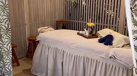 Cozy massage room at Enkardia Wellness, Γλυφάδα, GR featuring relaxing ambiance and plush treatment table.