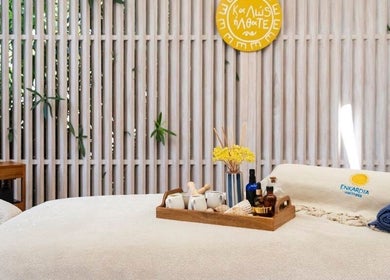 Tranquil massage room at Enkardia Wellness, Γλυφάδα, GR, with cozy linens and essential oils on a wooden tray.