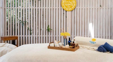 Tranquil massage room at Enkardia Wellness, Γλυφάδα, GR, with cozy linens and essential oils on a wooden tray.