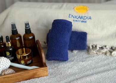 Relaxing spa essentials at Enkardia Wellness, Γλυφάδα, GR with oils, towels, and shells.