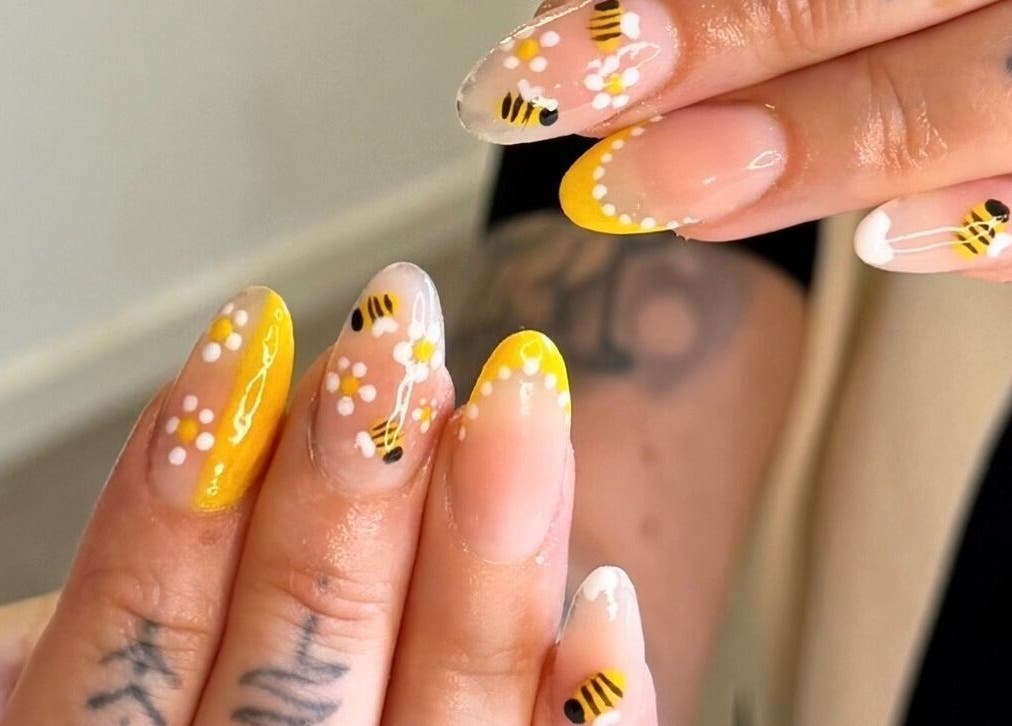 Bee-themed nail art at BeauteDeLuxeByMia, Selsey, England, GB. Features intricate bee and flower designs.