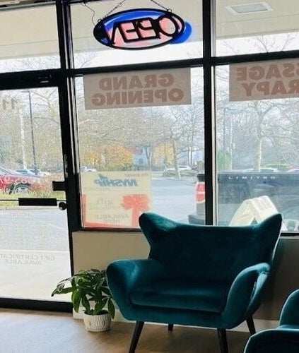 Inviting seating area in Stony Brook, New York, US spa with teal chairs by large windows.