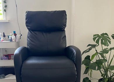 Comfy black chair at Nailed by Joanne, Driebruggen, Zuid-holland, NL, surrounded by plants and nail products.