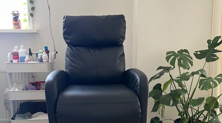Comfy black chair at Nailed by Joanne, Driebruggen, Zuid-holland, NL, surrounded by plants and nail products.