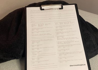 Client form for treatments at Majestic Beauty, Plymouth, England, GB, on a clipboard with a towel.