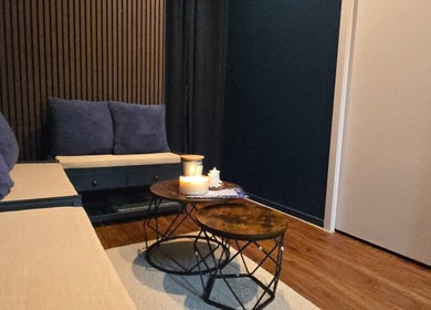 Relaxing ambiance at 7Breaths Massage Boutique, Auckland, NZ. Cozy seating with soft pillows and calming candles.