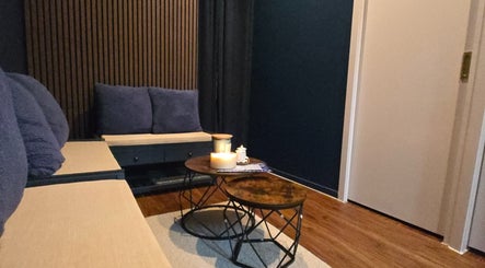Relaxing ambiance at 7Breaths Massage Boutique, Auckland, NZ. Cozy seating with soft pillows and calming candles.