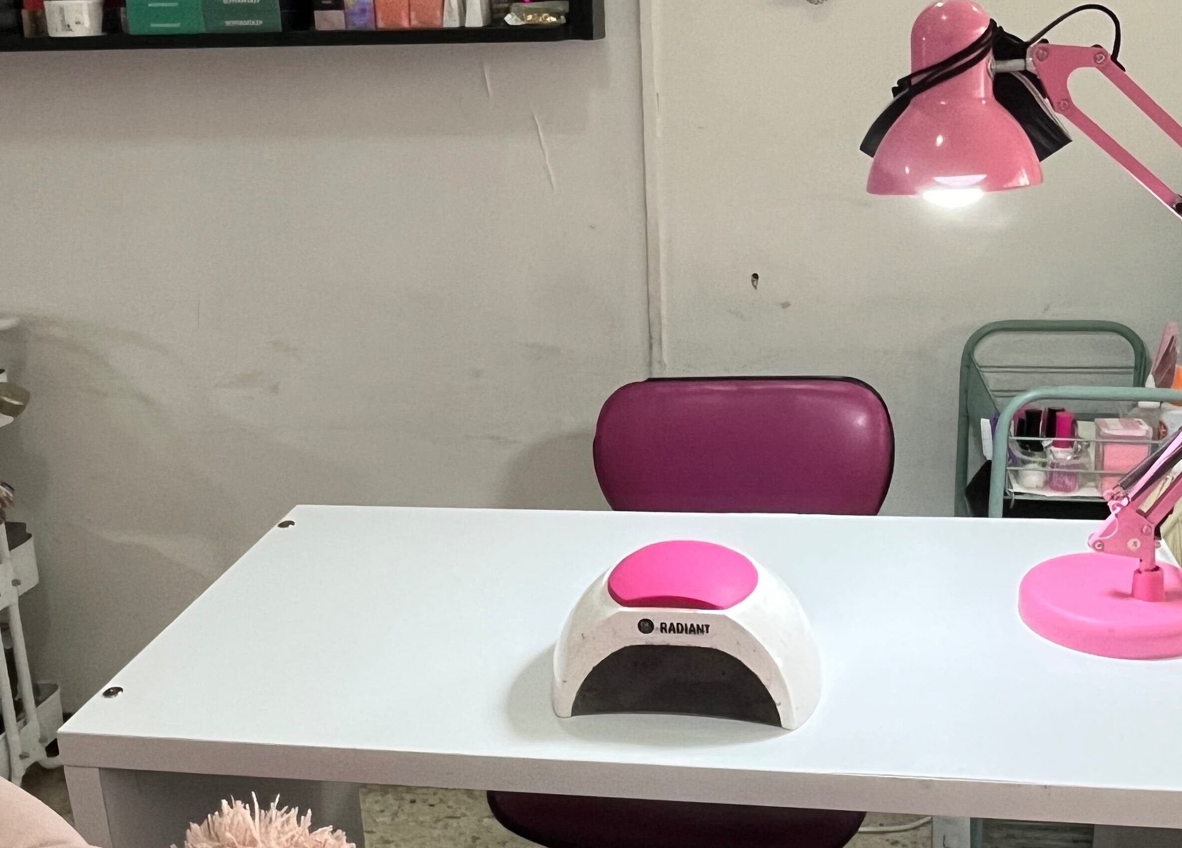 Mesa de manicura en Páramo Nails Qro, Santiago De Querétaro, Querétaro, MX, con lámpara rosa y herramientas.